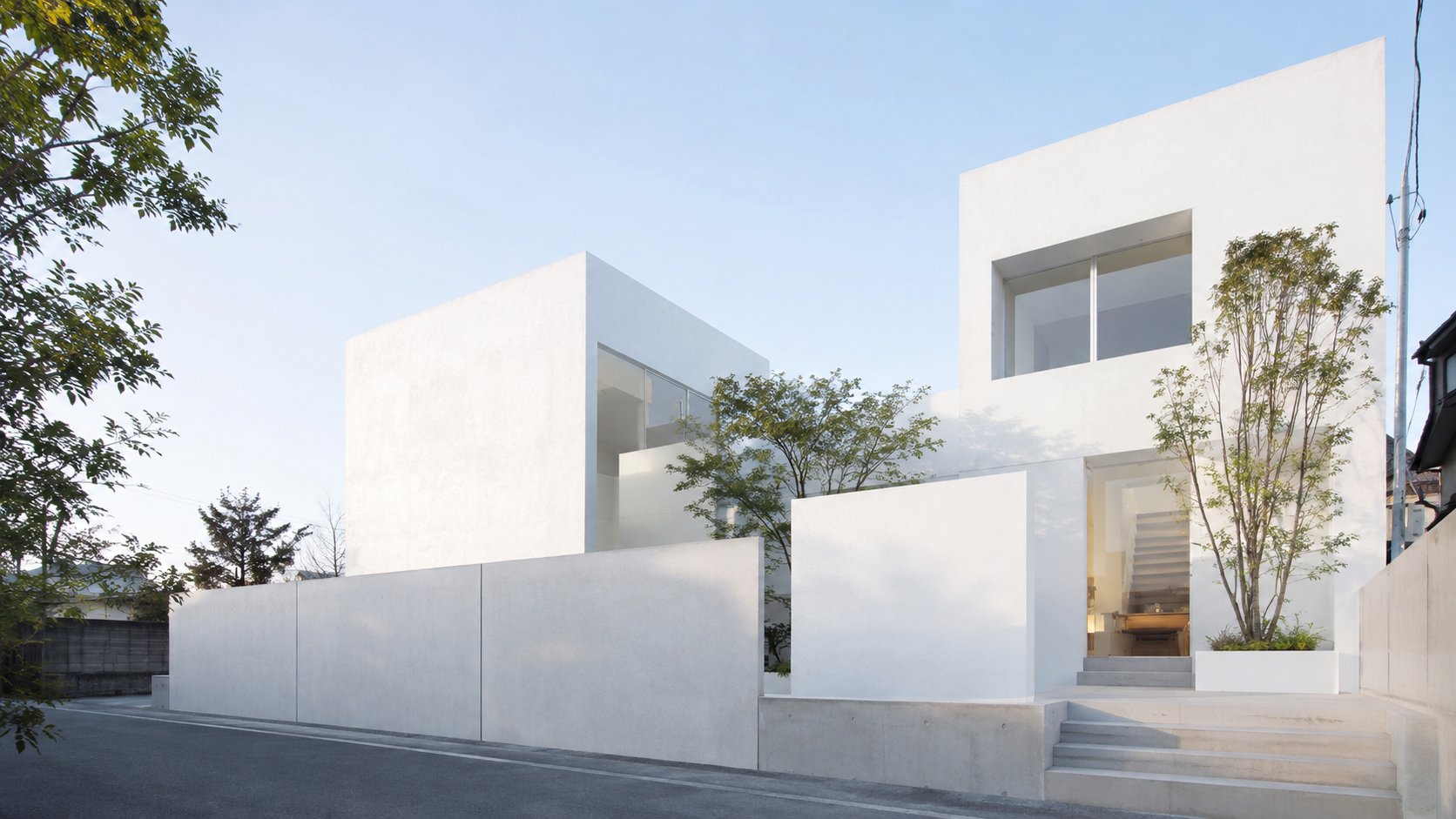Fachada blanca minimalista con árboles